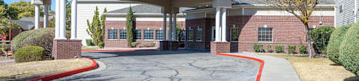 A building with a covered entrance and a red line on the pavement.