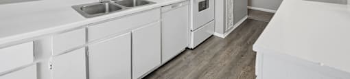 A kitchen with white cabinets and appliances.