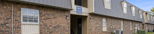 A parking lot in front of a brick building with a blue sign that says "4310".