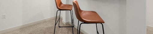 a kitchen with two stools in front of a bar with two chairs