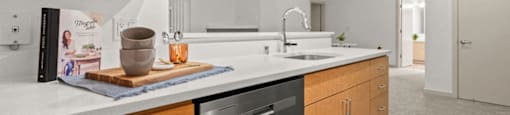 A modern kitchen with wooden cabinets and a stainless steel dishwasher.