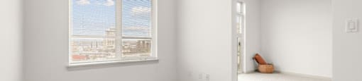 A room with a large window and a carpeted floor.