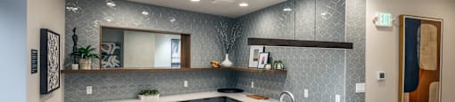 A modern kitchen with a white countertop and stainless steel appliances.