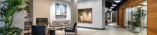 A modern office lobby with a wooden floor and a variety of seating options.