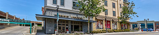 A street view of a building with a parking area in front.