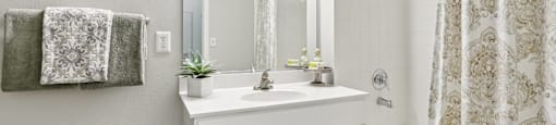 A bathroom with a white sink and a shower with a curtain.