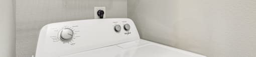 A white washing machine with a basket on top of it.