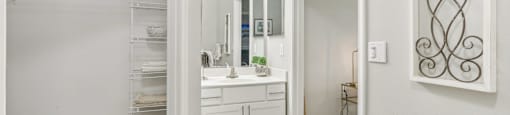 A bathroom with a white vanity and a large mirror.