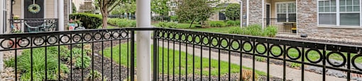 A black metal fence with a gate stands in front of a building.