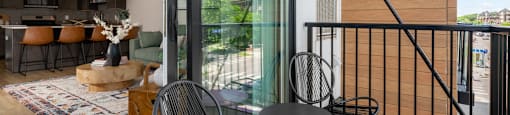 A balcony with a table and chairs overlooks a building.