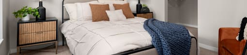 A bedroom with a bed, nightstand, and two wall art pieces.