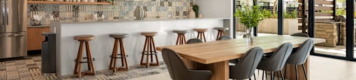 A modern kitchen with a wooden ceiling and a dining table with chairs.