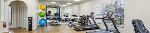 A gym with treadmills, exercise balls, and other equipment.