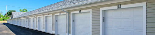 A long row of white garage doors are closed.
