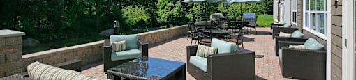 A patio with a table and chairs surrounded by trees.