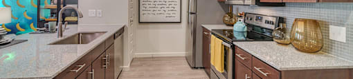 A kitchen with brown cabinets and a fridge.