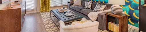 A living room with a grey couch and a wooden side table.