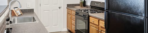 a kitchen with black appliances and wooden cabinets