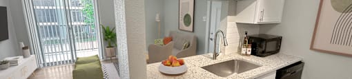 a kitchen with white cabinets and a granite counter top