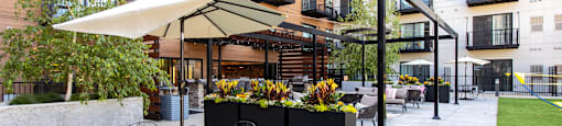 A patio with a table and chairs is surrounded by apartment buildings.