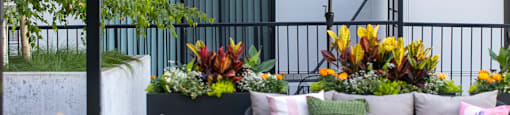 A patio with a white umbrella and a black railing.