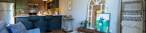 A living room with a grey couch and a glass table.