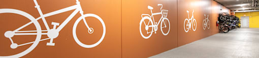 A bike parking area with orange walls and white bicycle symbols.