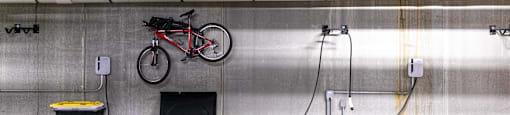 A red bicycle is parked in a parking garage.