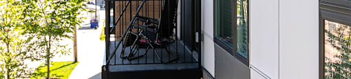 A white building with a balcony and a black railing.