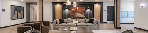 A modern living room with grey couches and a wooden coffee table.