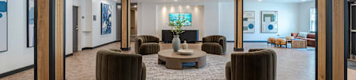 A spacious living room with a central coffee table and multiple seating options.