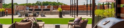 a patio with a grill and tables and chairs