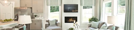 A modern living room with a grey couch and a fireplace.