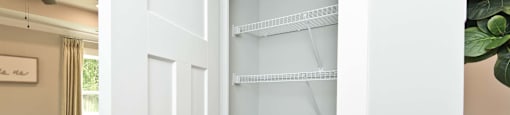 A white door with a shelf is open.