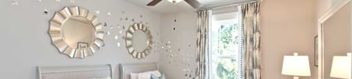 A bedroom with a white bed and a ceiling fan.