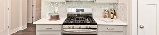 A kitchen with a stove top oven and a range hood above it.