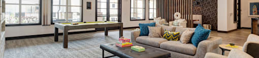 A living room with a grey carpet and a wooden ceiling.