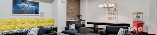 A modern living room with grey couches and a yellow sofa.