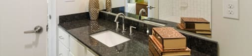 Ashland Farms Bathroom Vanity with Spacious Granite Counters, Large Mirror, and Modern Light Fixtures