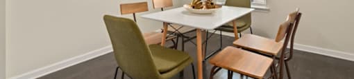 Dog-Friendly Apartments in Ashland City, TN - Ashland Farms - Dining Room with Wood-Inspired Plank Flooring, Table and Six Chairs, Mounted Wall Art, Sun-Framed Gold Mirror, Window, and Hanging Light Fixture.