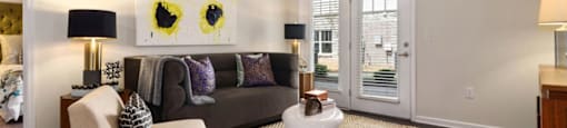Apartments For Rent Ashland City, TN - Ashland Farms - Spacious Living Room with Sofa, Chair, End Tables, Lamps, Wood-Style Flooring, Ceiling Fan, and Access to Patio
