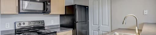 a kitchen with a stove refrigerator and sink