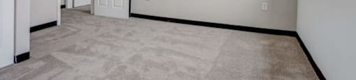an empty living room with white walls and a door