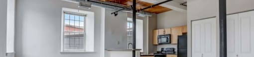 an empty living room and kitchen in a loft