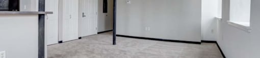 an empty room with white walls and a garage door