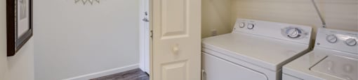 a white washer and dryer in a laundry room with a white door