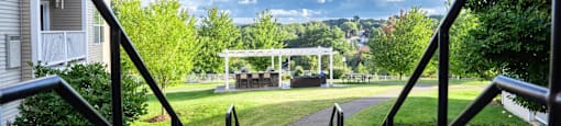a view of a park with a gazebo in the distance from stairs