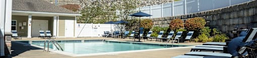 a swimming pool with lounge chairs and a building in the background