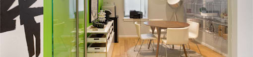 A conference room with a green wall and a glass door.