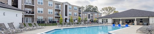 A large swimming pool in front of apartment buildings.